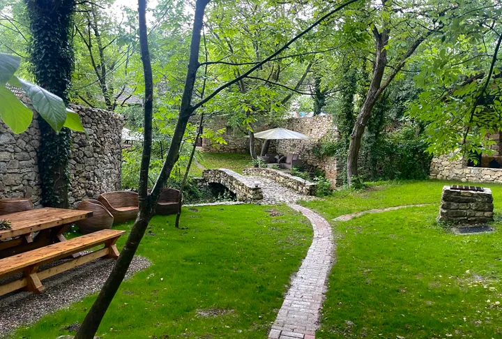 Winding garden path through stone structures and greenery